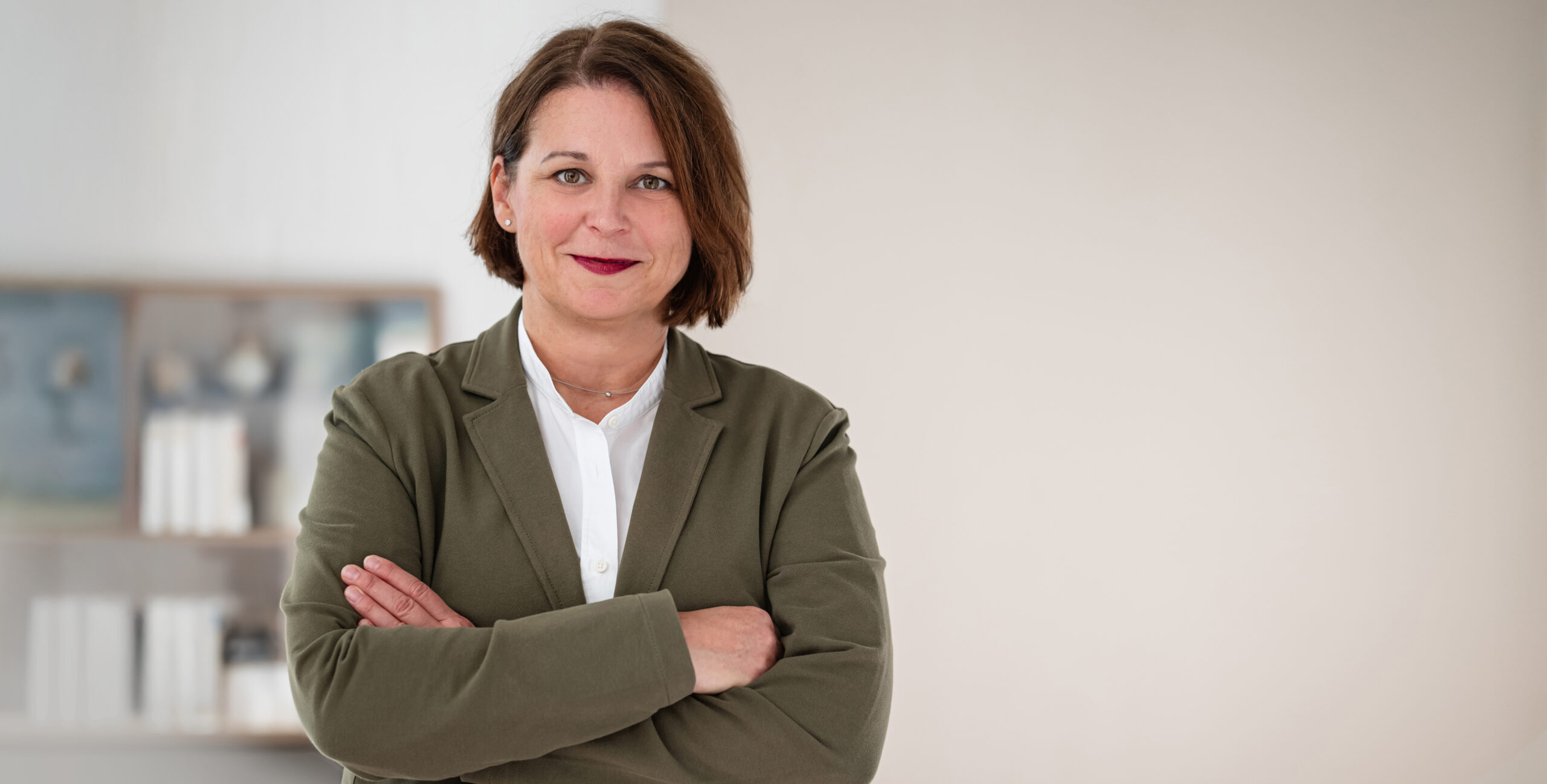 Das Foto zeigt Yvonne Friedland freundlich in die Kamera schauend in einem Büro